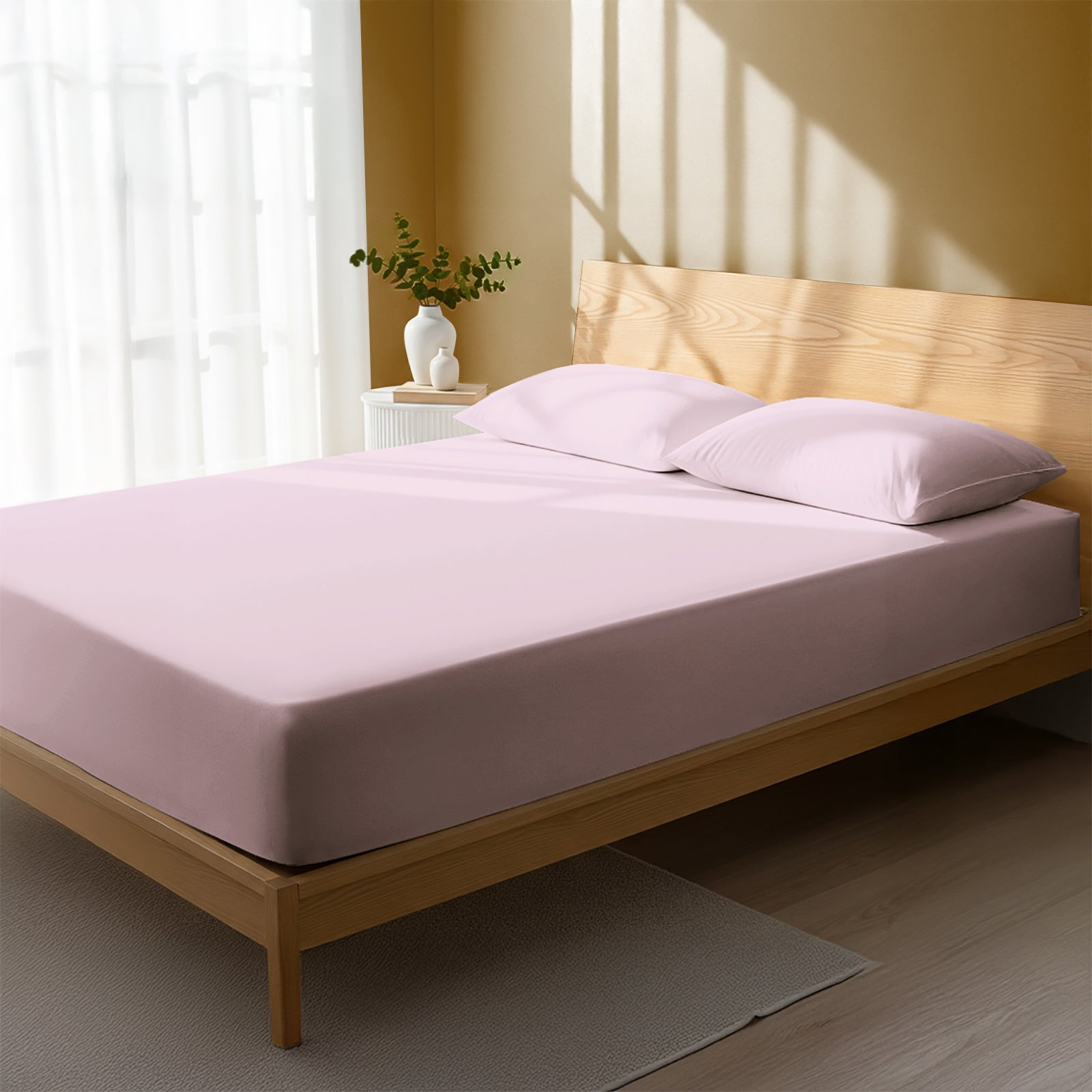 Bed in bedroom dressed with luxurious 1000 thread count light pink Double