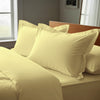 Mellow yellow oxford standard pillowcases deluxe 600 thread count on pillows on bed in bedroom