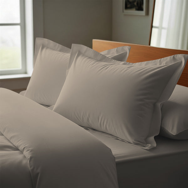 Simply taupe oxford standard pillowcases deluxe 600 thread count on pillows on bed in bedroom
